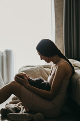 Young mother, holding tenderly her newborn baby girl, close portrait