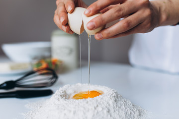 Female Hands Beat the Egg Yolk Into the Flour