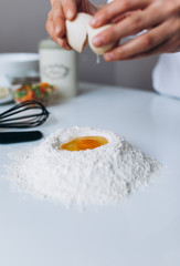 Female Hands Beat the Egg Yolk Into the Flour