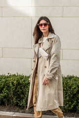 Portrait shooting of a stylish girl. Beige shades. Trends of spring and summer 2019. Pants of cork.Trench cloak, a wide jacket.