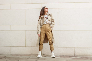 Portrait shooting of a stylish girl. Beige shades. Trends of spring and summer 2019. Pants of cork.Trench cloak, a wide jacket.