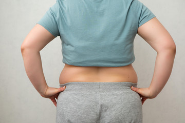 fat girl on diet, Overweight fat woman with a little portion of food trying to lose weight. Extreme diet,woman's hand holding excessive belly fat, the concept of weight loss