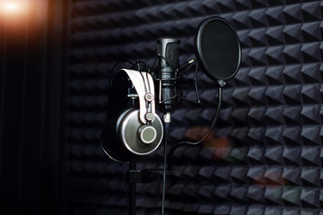 Microphone close-up on background professional recording Studio. Workplace singers and musicians. Microphone stand and headphones for recording vocals, speakers and sound musical instruments