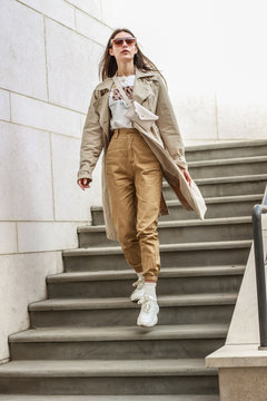 Portrait shooting of a stylish girl. Beige shades. Trends of spring and summer 2019. Pants of cork.Trench cloak, a wide jacket.