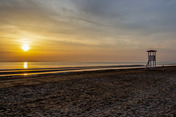 Summer sunrise at an empty sandy Senigallia beach with a lifeguard tower, Province of Ancona,...