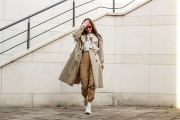 Portrait shooting of a stylish girl. Beige shades. Trends of spring and summer 2019. Pants of cork.Trench cloak, a wide jacket.