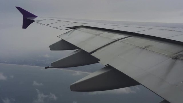 Wing of airplane flying above the sea