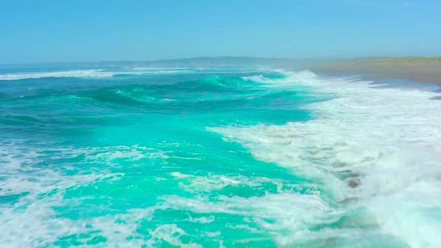 Overhead drone view aerial of turquoise green waves  in northern california.