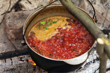 Ukrainian traditional soup cooking in old sooty cauldron