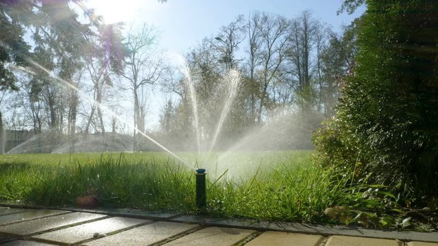 Summer city landscape. Automatic watering system for plants and lawn. 4K