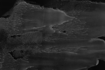 Black alcohol ink texture with abstract washes and paint stains on the white paper background.	