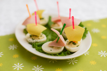 Children's food in the form of ships. Creative sandwiches of eggs in the form of ships. Children's menu on a green background