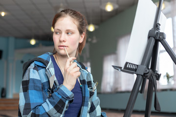 Girl artist in the process of drawing oil paintings.