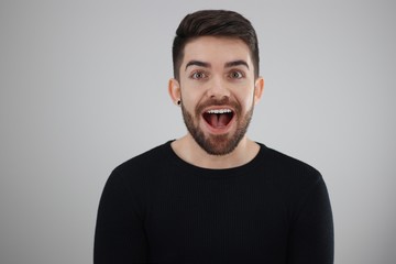 extremely happy man with open mouth smiling - young man receiving an excellent news - whit space for caption or text