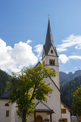 Fototapeta na wymiar View of Church surrauded by mountains in Arabba village, Dolomites Alps, Italy