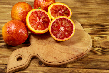 Red blood oranges on wooden table
