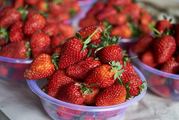 Fresh strawberry in a plastic bowl, close-up, top view, healthy detox food