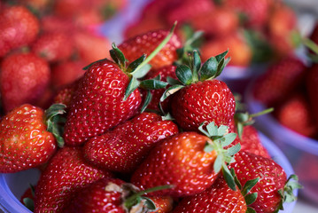 Fresh strawberry in a plastic bowl, close-up, top view, healthy detox food