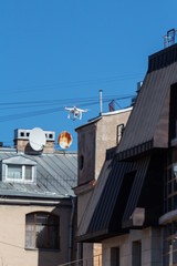 Fototapeta na wymiar drone quadcopter with digital camera flies near residential city buildings with windows