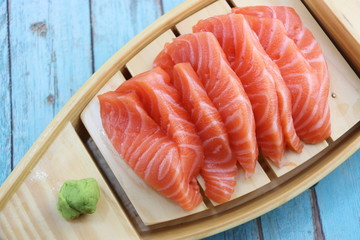 Sashimi saumon et wasabi sur une barque à sushi