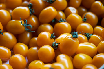 Yellow cherry tomato food background, close-up, top view. 