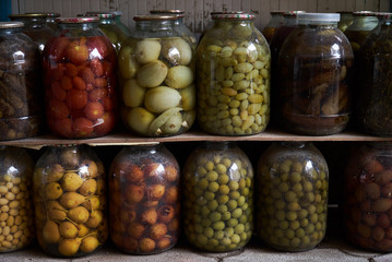 Jars with variety of pickled vegetables and fruits in food market