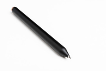 A macro shot of a minimalist sleek black barrel clicker ballpoint pen with selective focus on its writing tip.