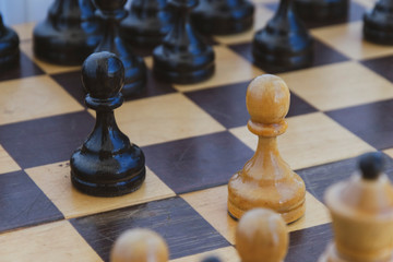 black and white chess pieces on a checkered board. the beginning of the game of chess