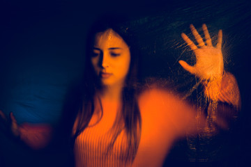 Portrait of teenage girl trapped behind the plastic nylon foil, human rights antipollution trafficking concept