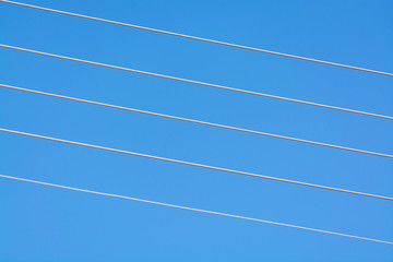 Empty music staff concept photo of 5 electric wires on blue sky, music creation template