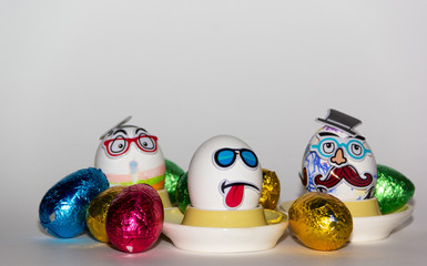 Mr. moustache, worried egg and cool Easter egg on a white background surrounded with colorfull eggs