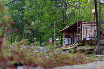 Small train station wih many graffities near a park
