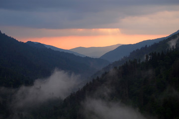 Sunset behind layered mountains under a dramatic cloudscape in the Great Smoky Mountains National Park, Tennessee, in early summer.