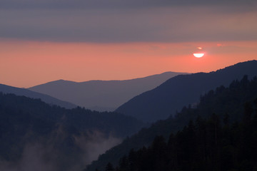 Sunset behind layered mountains under a dramatic cloudscape in the Great Smoky Mountains National Park, Tennessee, in early summer.