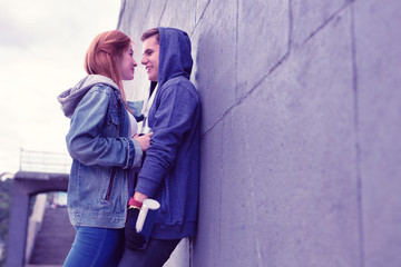 Passionate young couple having lovely moments while leaning on the wall