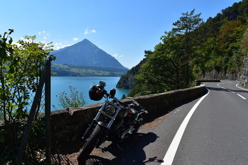 Motorbike parked at road side by the Lake Thun of Switzerland and mountains in background in a very nice and sunny summer day