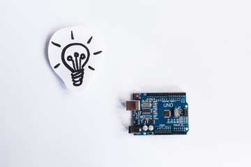 Arduino Uno. Arduino. Micro controller. Technology. Picture of a light bulb in the background. Idea. The science.
