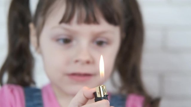 Lighter and child. Little girl plays with fire in a lighter.