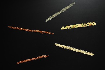 Groats on a black background. Buckwheat. Rice groats. Millet. Flax grains. A set of cereals.