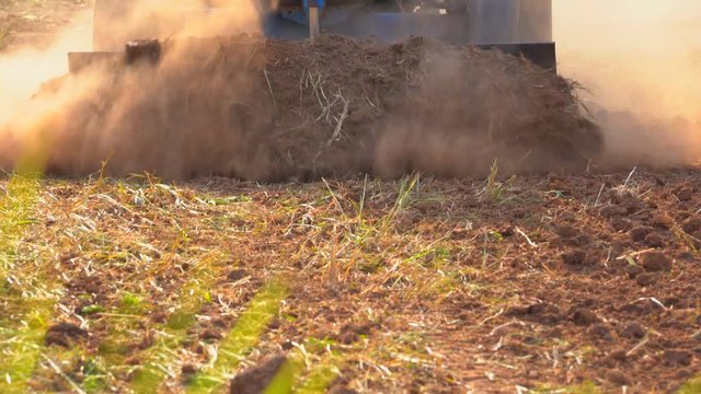 Slow motion tractor plowing in rice field organic farm agriculture