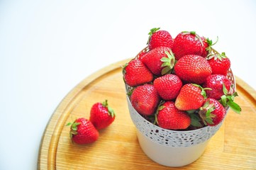 Red strawberries on a white background in a bowl. Red berries. Fruits on the plate. Berries for the cake. Strawberry basket. A group of berries. Fresh fruit and juicy fruit for fruit drink.