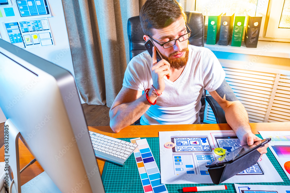Poster graphic designer testing the application on the tablet. design for mobile devices. portrait of young