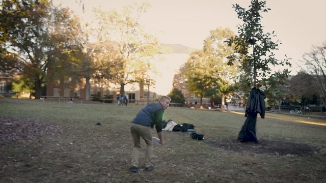 Two male college students playing frisbee at a university campus