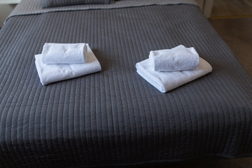 Clean towels on bed at hotel room. Bed interiors.