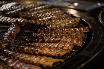 BBQ Roast Marinated Baby Back Pork Ribs. Close-up On Hot Flaming Grill Background
