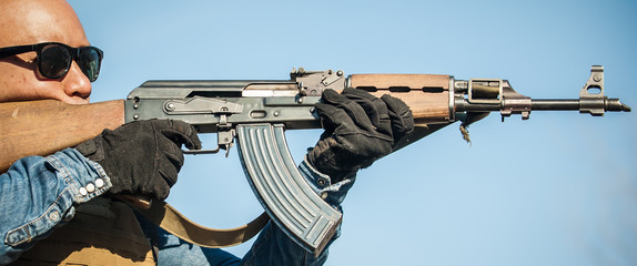 Military soldier in action combat shooting from rifle machine gun