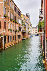 Water canal between buildings in the city of Venice, Italy, where there are no motor vehicles; only boats and other water vessels are used for transportation.