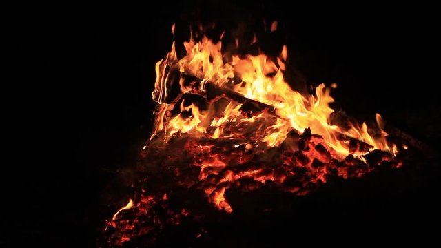 Home style footage. No sound. Thirty 30 seconds of bonfire or campfire for Guy Fawkes theme by a body of water at dusk. Relaxing and romantic