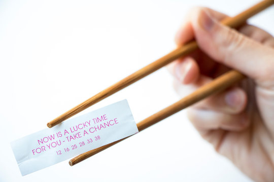 Chopsticks in hand, holding a cookie fortune "Now is a lucky time for you - take a chance."