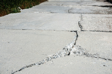 Crack in concrete slab of coastal promenade as result of sea water erosion